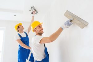 Two workers are repairing the ceiling.