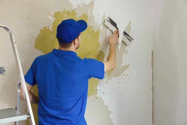 worker removing wallpaper